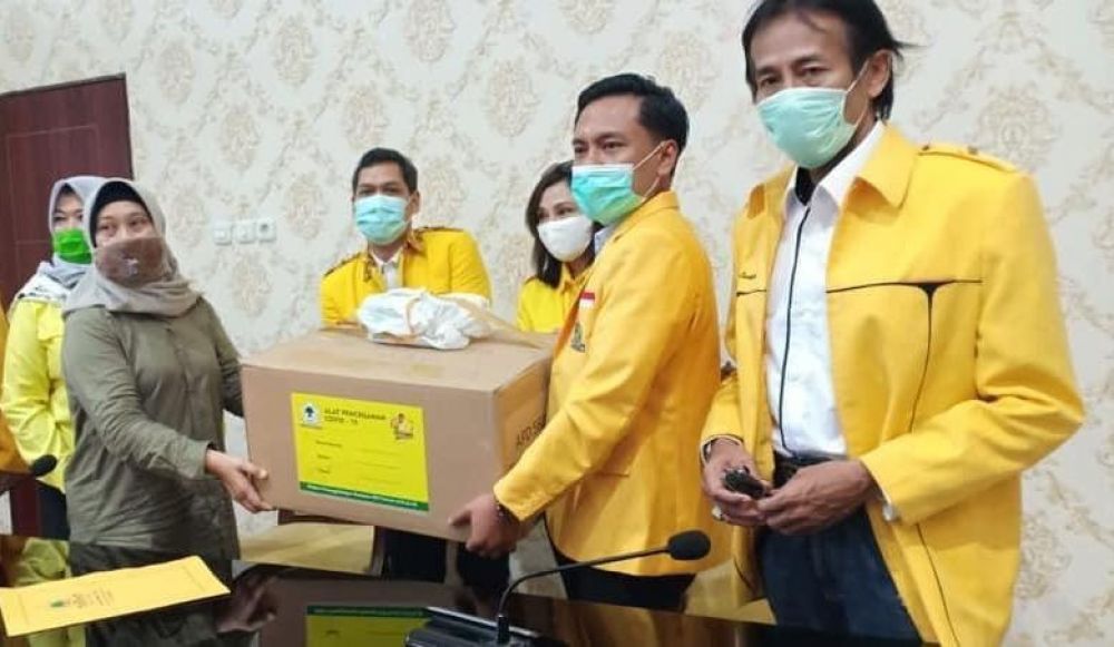 LAWAN CORONA: Anggota fraksi Golkar memberikan bantuan kepada warga yang terdampak Covid-19.  Foto: HMP/Guntur