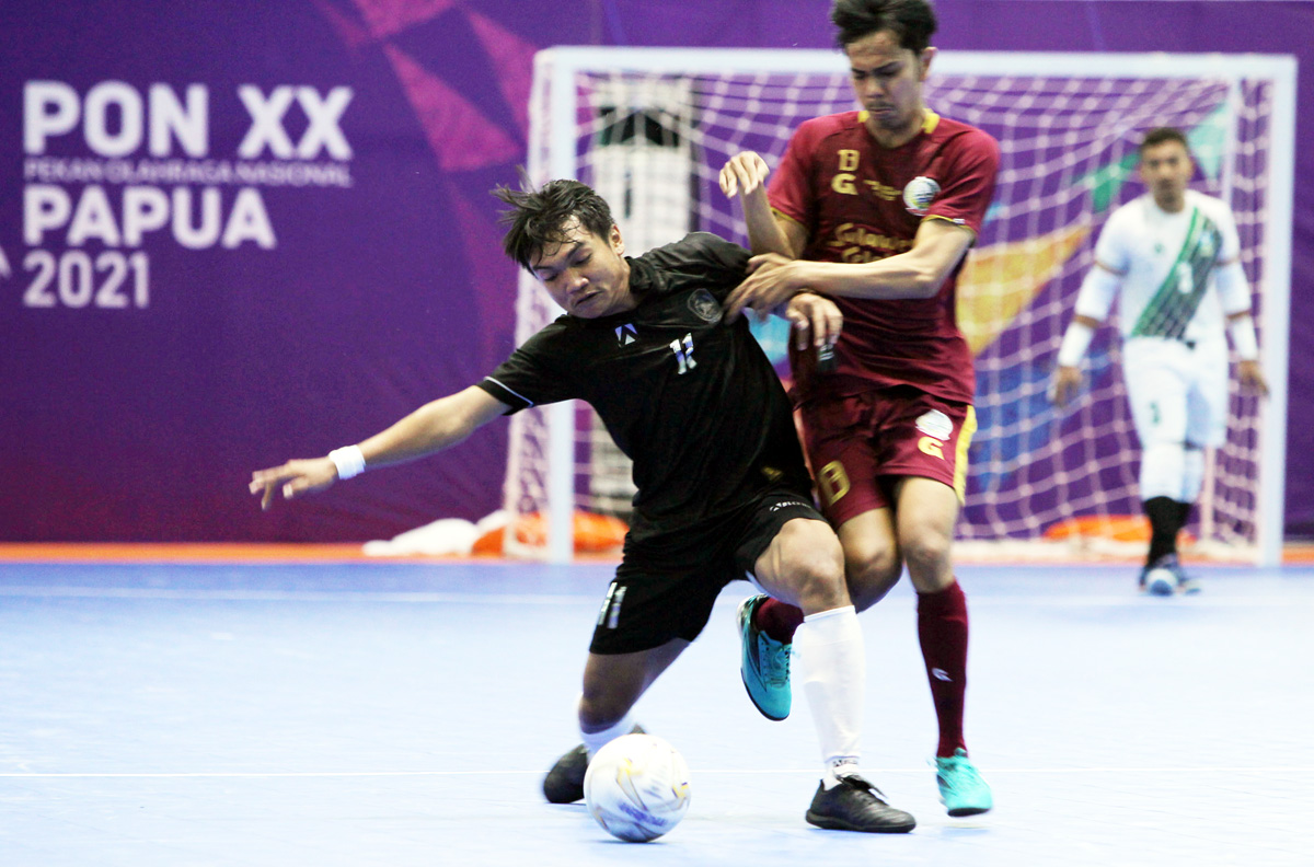 Pemain Jawa timur Andrianto Athala Tomassi (kiri) berebut bola dengan pemain Sulawesi Selatan Residin Nasution dalam pertandingan futsal babak penyisihan PON XX di GOR Futsal SP/2, Sabtu 25/9.  Foto : PB PON XX Papua/Maleachi Marinsib Palinggi 