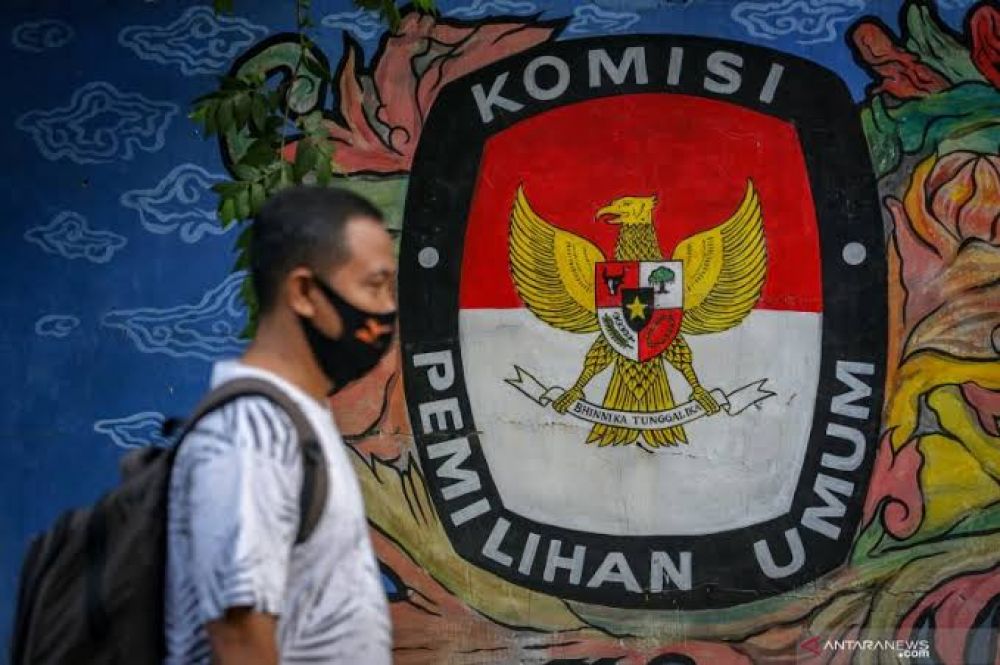 Warga melintas di depan mural bertema pemilihan umum di kawasan Pasar Anyar, Kota Tangerang, Banten, Kamis (7/5/2020). Presiden Joko Widodo menunda pemungutan suara Pemilihan Kepala Daerah (Pilkada) 2020 hingga Desember 2020 akibat wabah COVID-19. 
