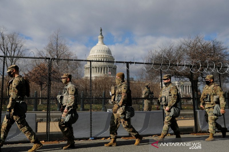 Anggota Garda Nasional berpatroli dekat gedung Capitol menjelang pelantikan Presiden terpilih Joe Biden, di Washington, Amerika Serikat, Selasa (19/1/2021). REUTERS/Andrew Kelly/WSJ/djo (REUTERS/ANDREW KELLY)
