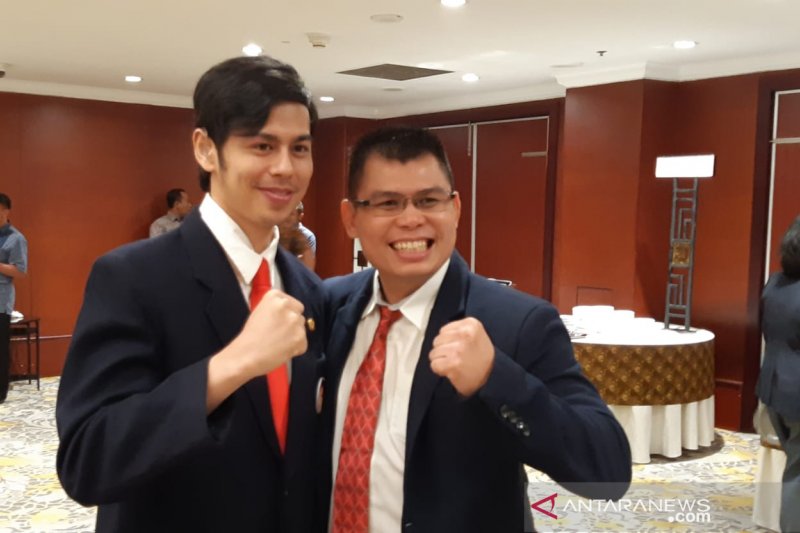 Mantan petinju nasional Chris John (kanan) berpose dengan pengurus KONI Pusat lainnya Panji Surya Sahetapy di sela pengukuhan dan pelantikan pengurus Komite Olahraga Nasional Indonesia (KONI) Pusat periode 2019-2023 di Hotel Borobudur Jakarta, Kamis (1/8/