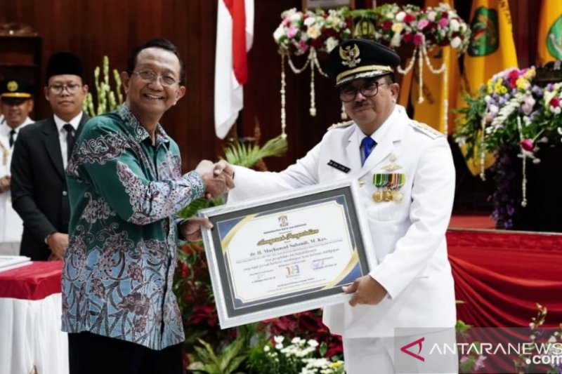 Mantan Kepala Dinas Kesehatan (Kadinkes) Kota Balikpapan dr M. Subandi (kiri) saat menerima penghargaan dari Wali Kota Rizal Effendi pada 2019 lampau. (istimewa)

