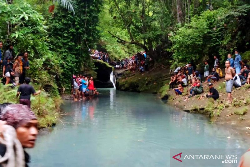 Warga berkerumun di pinggir sungai tempat dua saudara tenggelam di Kabupaten Jembrana, Jumat (1-1-2021). ANTARA/Gembong Ismadi
