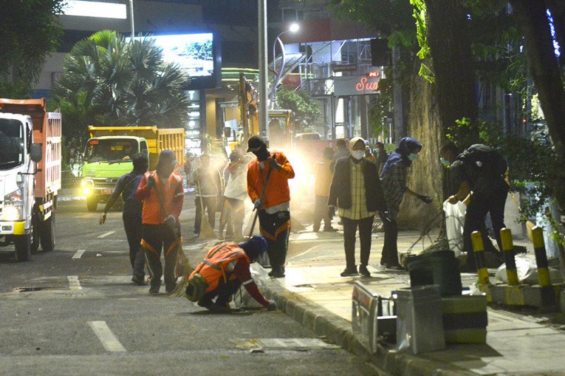 Wali Kota Surabaya Tri Rismaharini memimpin petugas pemerintah membersihkan jalan usai demonstrasi untuk memprotes UU Cipta Kerja di Kota Surabaya, Jawa Timur, Kamis (8/10/2020) malam. (ANTARA/HO-Humas Pemkot Surabaya)

