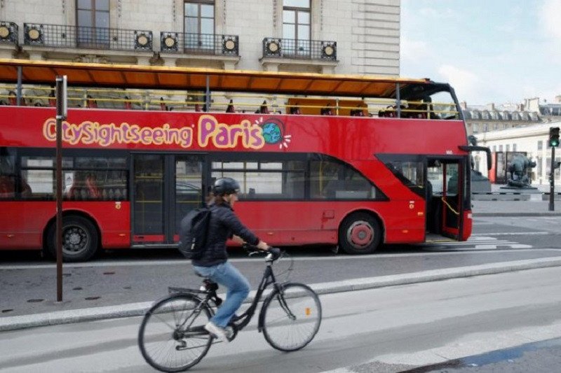 Foto dokumen: Seorang pengendara sepeda melewati bus wisata kosong di jalanan Paris, Prancis, 9 Maret 2020 (ANTARA/REUTERS/Pascal Rossignol)
